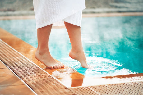 person dipping toe into pool during winter