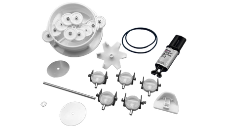 Pool valve rebuild kit with white gear housing, gears, O-ring, star wheel, tube, adhesive, and replacement valve components