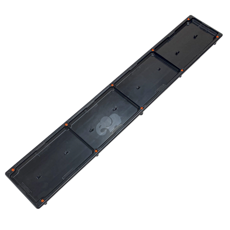 Black single pebble top channel drain insert with orange mounting points, angled view