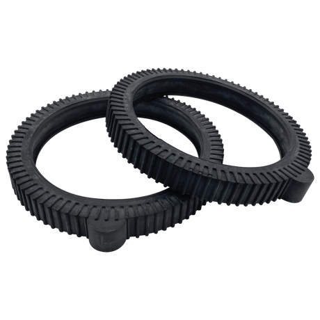 Two black solid rubber hump tires crossed on a white background