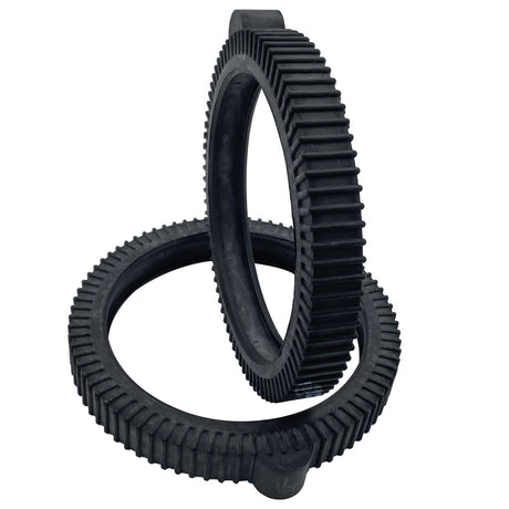 Two black solid rubber tire humps with ridged tread, shown interlocked on a white background
