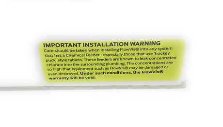 FlowVis installation warning label about chlorine-feeder placement; follow the complete current installation manual.